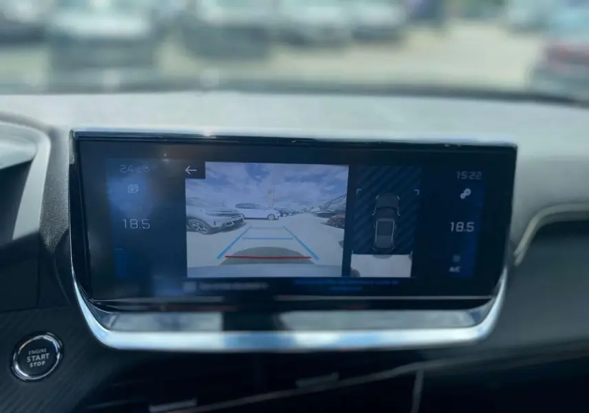 Écran tactile du Peugeot 2008 gris foncé montrant l’aide au stationnement arrière avec vue caméra et capteurs.