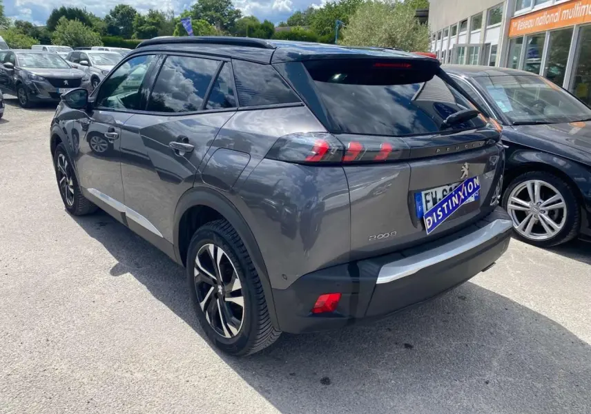 Peugeot 2008 gris foncé vue 3/4 arrière droit, jantes alliage bi-ton et toit noir brillant visible.