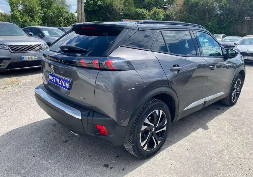 Peugeot 2008 gris foncé vue 3/4 arrière droit, avec jantes alliage bi-tons et toit noir brillant.