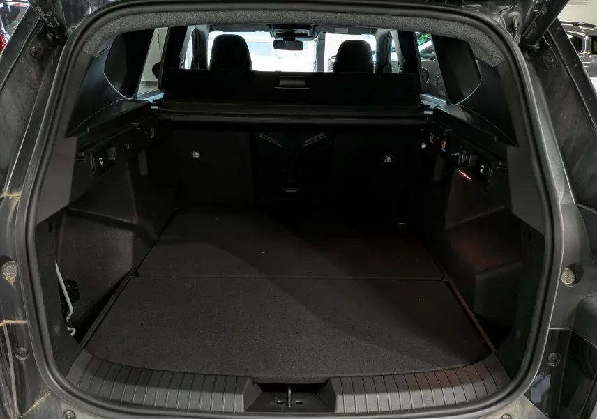 Vue arrière du coffre noir nacré du Dacia Bigster 2026, montrant un espace de chargement spacieux et bien fini.