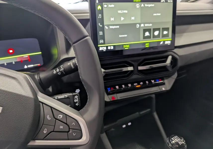 Vue intérieure côté conducteur du Dacia Bigster noir nacré 2026, avec volant multifonction et écran tactile central allumé.