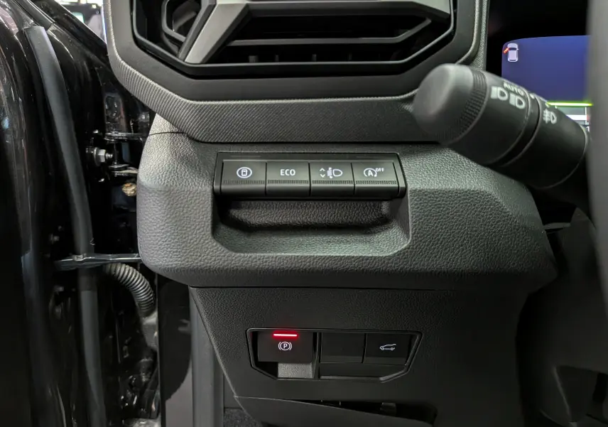 Détail intérieur côté gauche du tableau de bord du Dacia Bigster noir nacré, avec commandes d'assistance et régulateur.