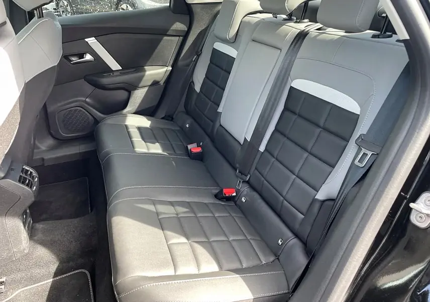 Vue côté droit de la banquette arrière bi-ton noir et gris du Citroën C4 X 1.2 hybride 2025 avec ceinture et appuie-têtes visibles.
