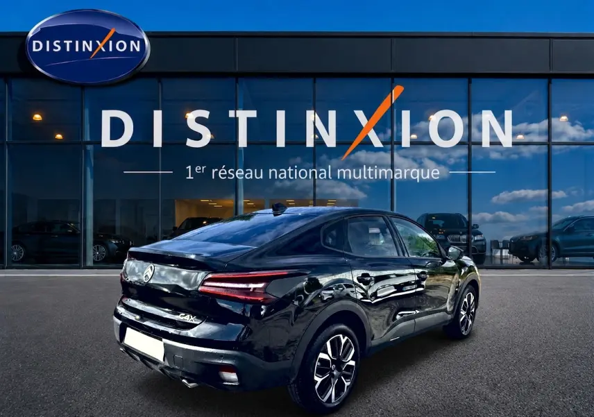 Vue 3/4 arrière droite d'une Citroën C4 X noire 2025 avec feux arrière LED et jantes alliage visibles.