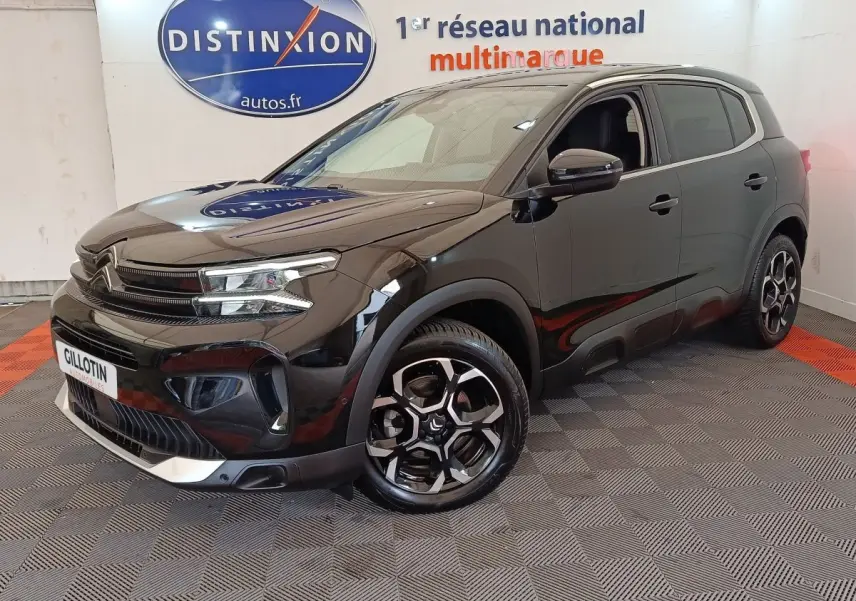 Citroën C5 Aircross noir en 3/4 avant droit, avec jantes distinctives et calandre moderne dans un showroom.