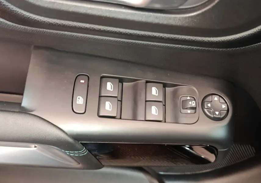 Vue rapprochée des commandes de lève-vitres et réglage des rétroviseurs côté conducteur du Citroën C5 Aircross noir 2024.