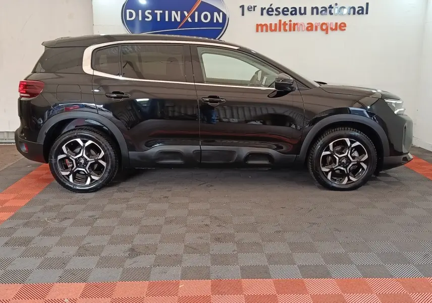 Vue de profil côté gauche d'un Citroën C5 Aircross noir 2024, avec jantes alliage et protections noires sur les bas de caisse.