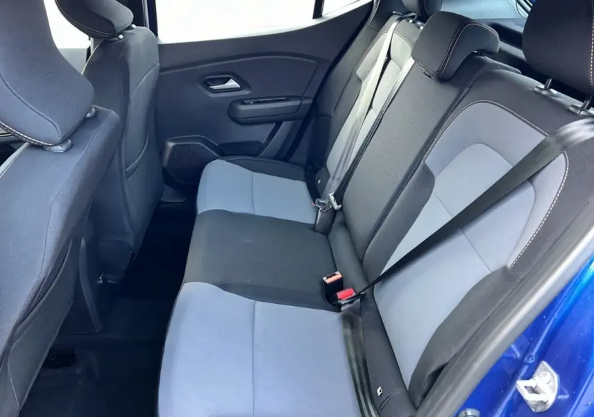 Vue intérieure arrière côté droit de la DACIA SANDERO Stepway 2024 en bleu iron avec sièges bicolores gris et noir.