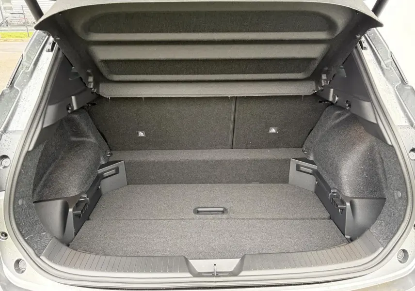 Coffre ouvert vu de l'arrière du Nissan Qashqai III gris foncé, montrant un espace de chargement vide et bien fini.