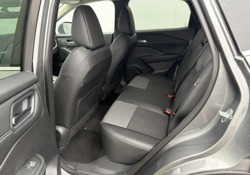 Vue côté droit de l'habitacle arrière du Nissan Qashqai III gris foncé, sièges mixtes cuir et tissu noirs.