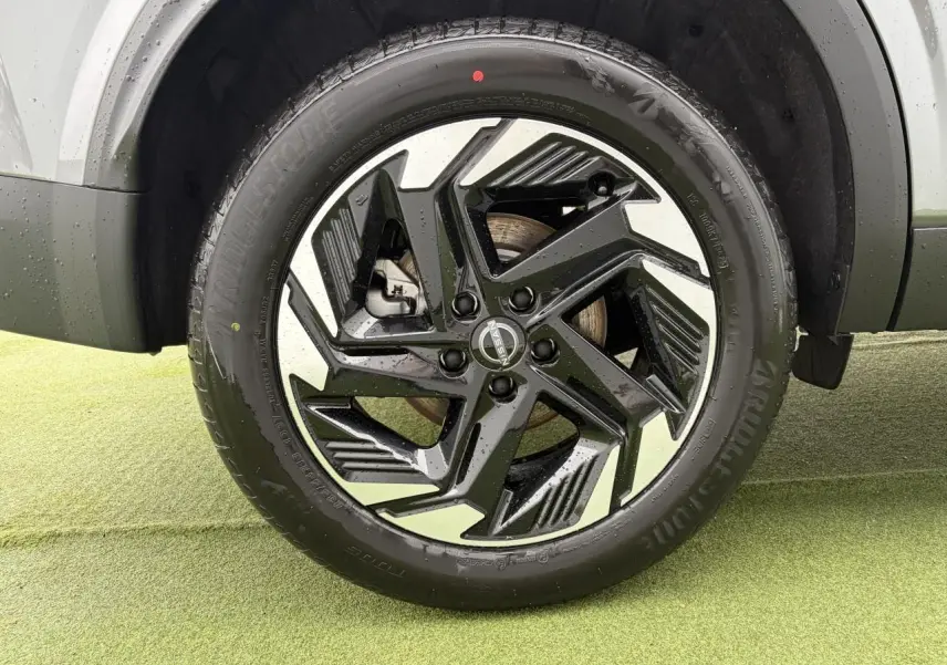 Gros plan sur la jante alliage 18 pouces bicolore noir et argent du Nissan Qashqai III gris foncé, roue avant droite.