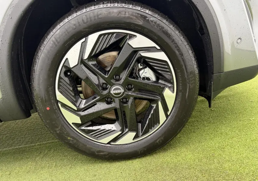 Gros plan sur la jante alliage 18 pouces bicolore noire et argent du Nissan Qashqai III gris foncé, roue avant droite.