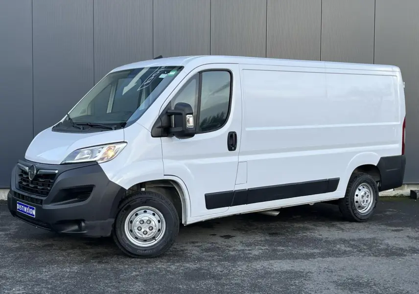 Vue 3/4 avant droit d’un fourgon Opel Movano blanc avec pare-chocs noirs et porte latérale coulissante.