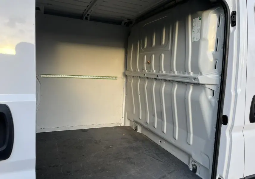 Vue intérieure de la zone de chargement du fourgon blanc Opel Movano, côté droit avec plancher et parois métalliques.