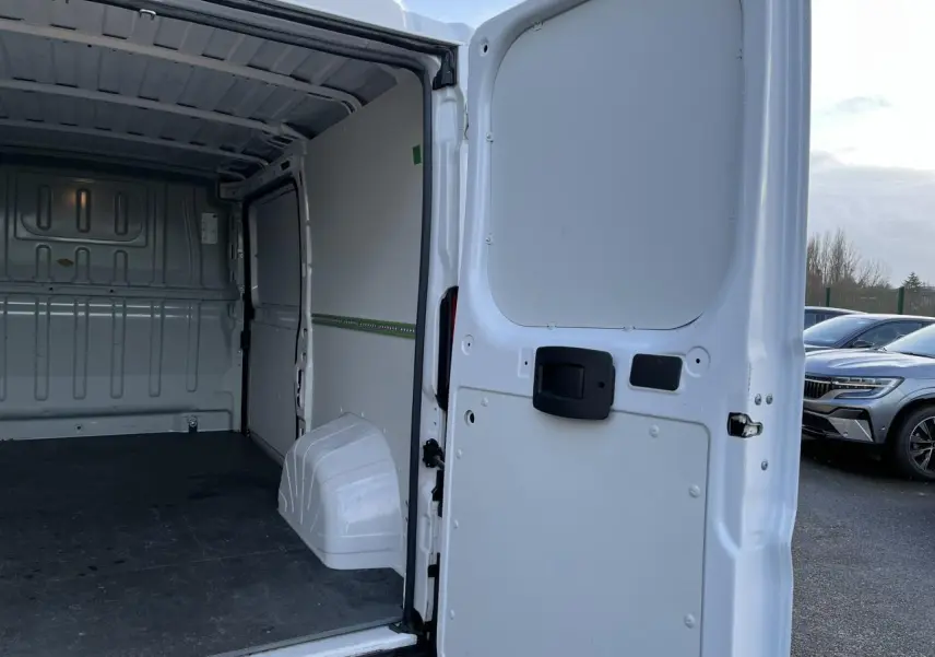 Vue arrière ouverte du fourgon blanc Opel Movano 2024, montrant l’intérieur vide et le plancher noir.