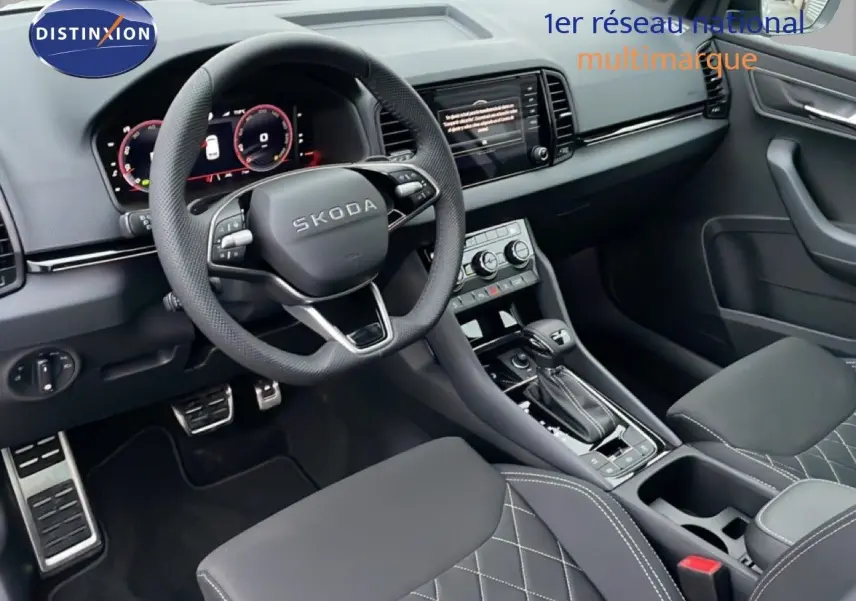 Intérieur noir du Skoda Karoq 2025, vue côté conducteur, volant multifonction et console centrale avec boîte auto.