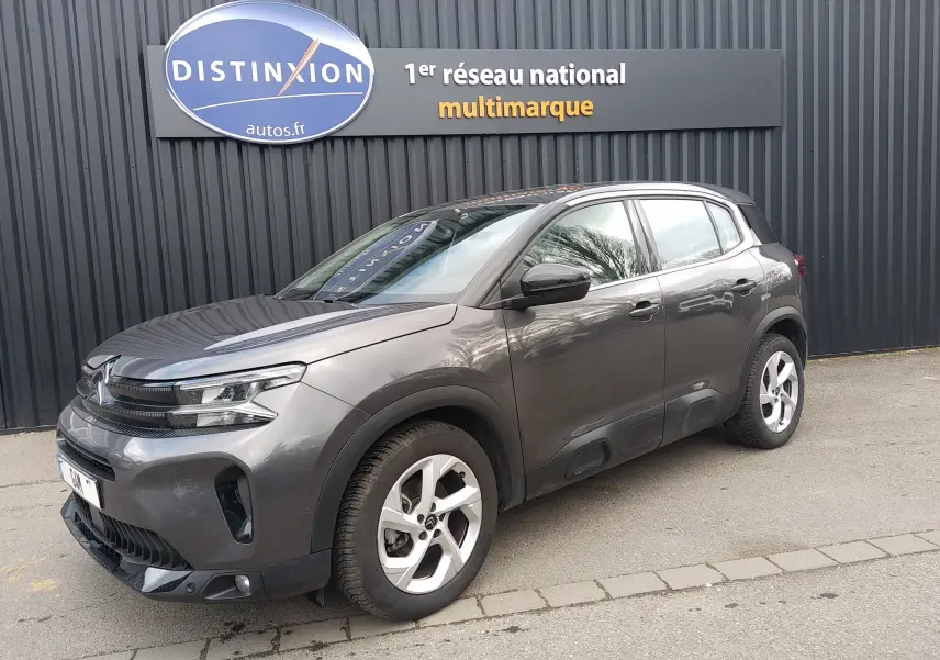 Vue 3/4 avant droit d’un Citroën C5 Aircross gris platinium 2023 avec jantes alliage et détails noirs contrastants.