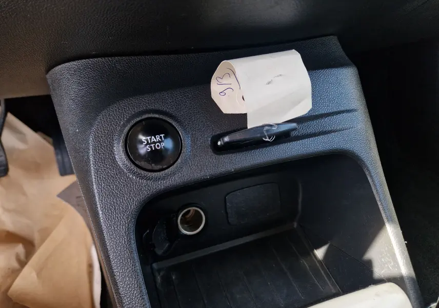 Gros plan sur la console centrale noire du Renault Captur ivoire 2018, avec bouton start/stop et prise allume-cigare visible.