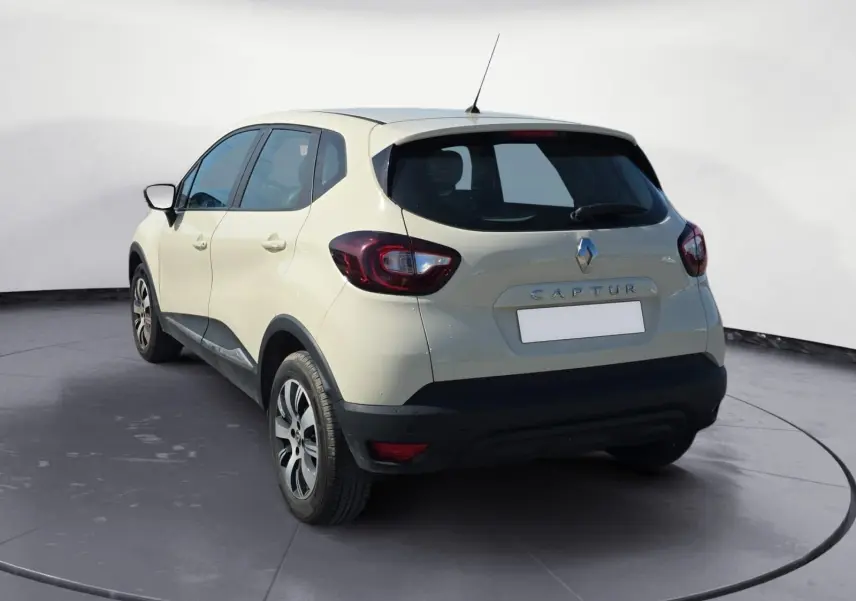 Renault Captur ivoire vue de profil côté gauche, avec jantes alliage noires et détails noirs sur les bas de caisse.