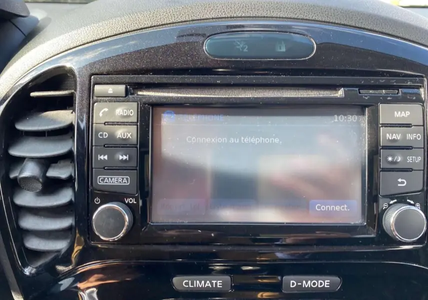 Gros plan sur le tableau de bord noir du Nissan Juke 2017, écran tactile affichant la connexion téléphone.