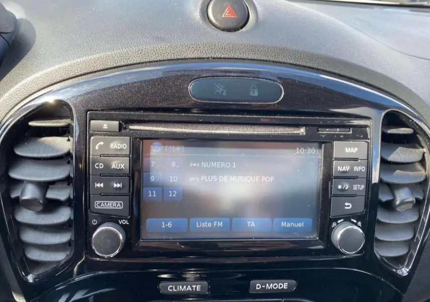 Vue rapprochée du tableau de bord noir du Nissan Juke 2017, avec écran tactile et commandes autour.