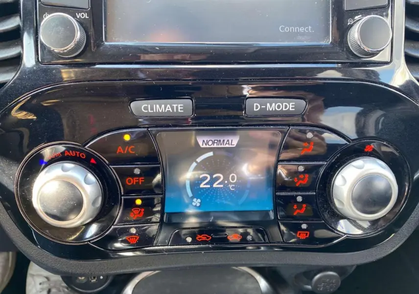Vue rapprochée de la console centrale du Nissan Juke 2017, affichant la climatisation automatique réglée à 22°C.