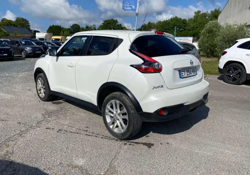 Nissan Juke blanc vue 3/4 arrière droit, jantes alliage 17 pouces et vitres arrière surteintées.