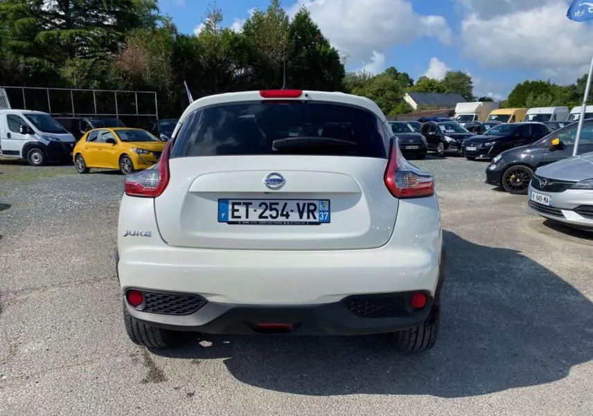 Vue arrière d'un Nissan Juke blanc avec feux arrière caractéristiques et plaque d'immatriculation française visible.