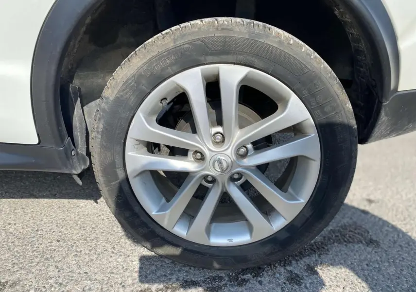 Gros plan sur la jante alliage 17 pouces argentée du côté avant droit d'un Nissan Juke blanc.