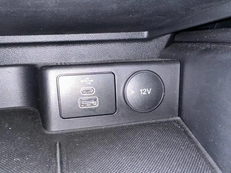 Gros plan sur la prise USB et la prise 12V dans l'habitacle noir de la Ford Focus Titanium 2023.