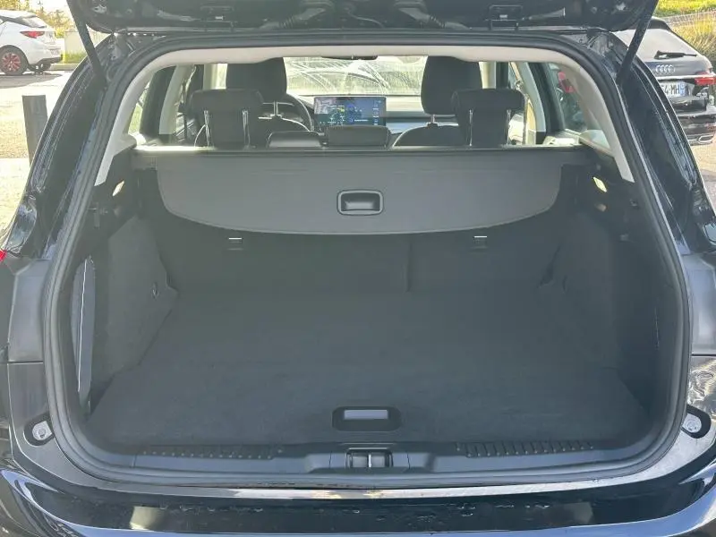 Vue arrière du coffre ouvert d'une Ford Focus 2023 noir Agate métallisé, montrant l'espace de chargement et la tablette arrière.