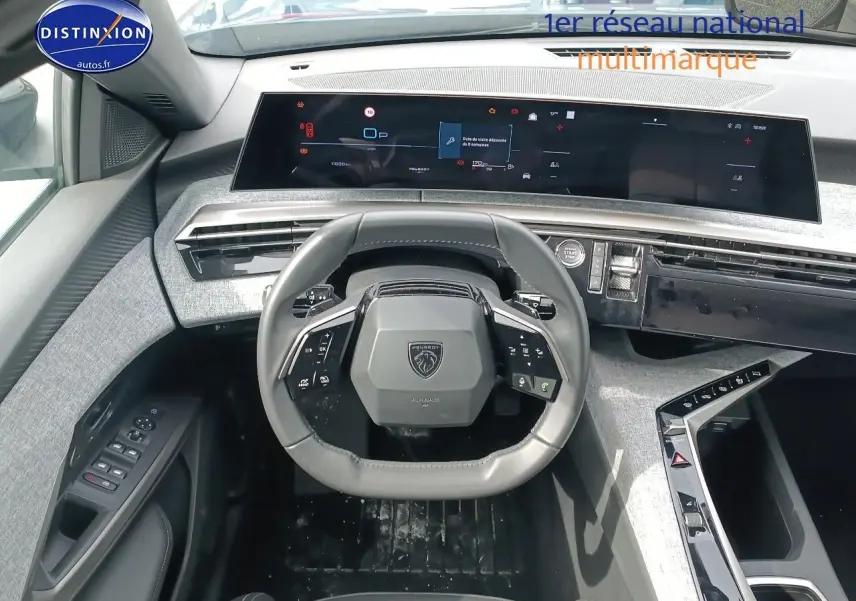 Vue intérieure centrée sur le volant cuir multifonction et le tableau de bord numérique du Peugeot 5008 Hybrid 145 allure.