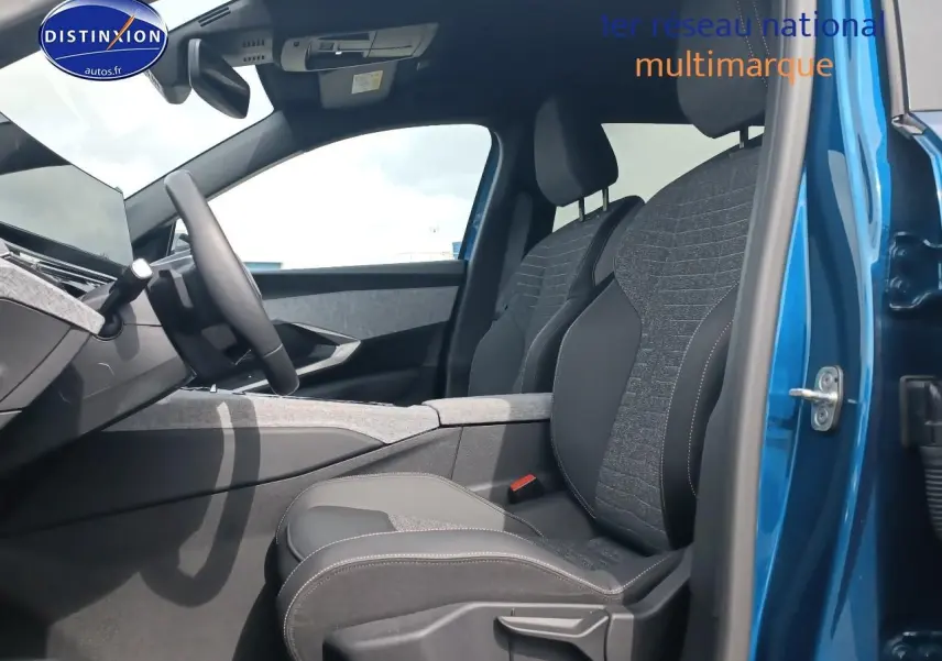 Intérieur côté conducteur du Peugeot 5008 Hybrid 145 allure bleu, sièges tissu et cuir, planche de bord moderne visible.
