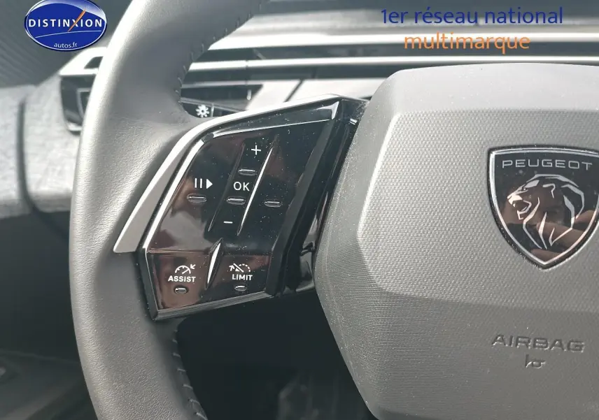 Gros plan sur le volant cuir multifonction gris du Peugeot 5008 Hybrid 145 allure, avec commandes intégrées au volant.