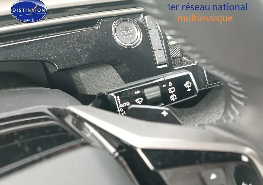 Détail intérieur du tableau de bord du Peugeot 5008 Hybrid bleu, avec bouton start/stop et commandes de vitres.