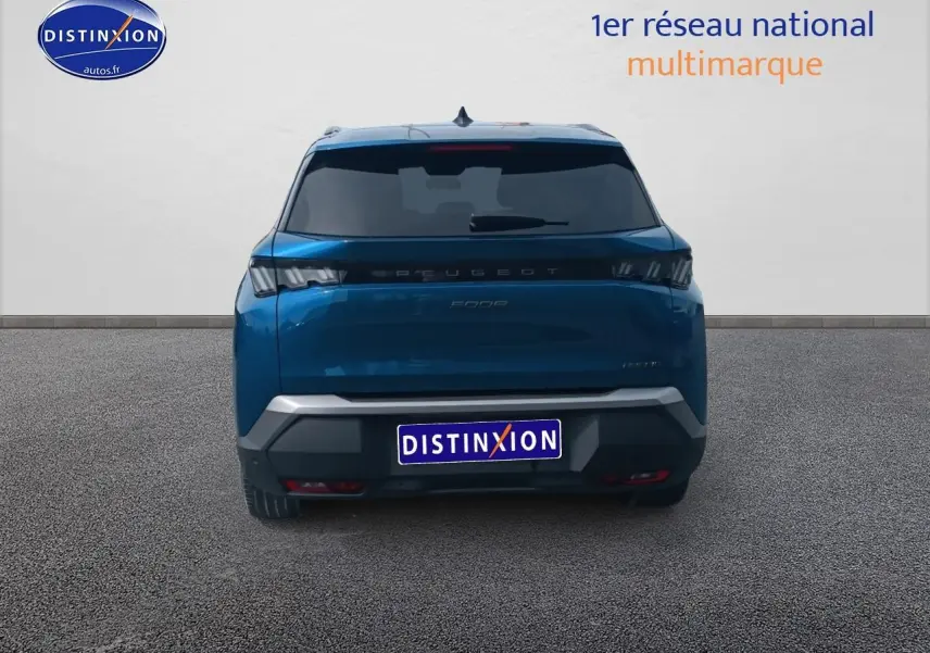 Vue arrière d'un Peugeot 5008 bleu 2025 avec feux LED et lunette arrière surteintée sur fond neutre.