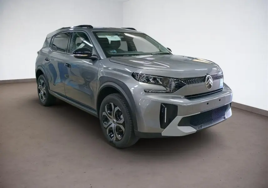 Vue 3/4 avant droit du Citroën C3 Aircross Hybrid 145 gris Mercury avec barres de toit noires et vitres surteintées.