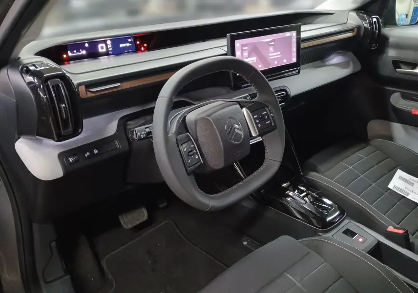 Vue intérieure côté conducteur du Citroën C3 Aircross 2025, tableau de bord moderne avec écran tactile et volant multifonctions.