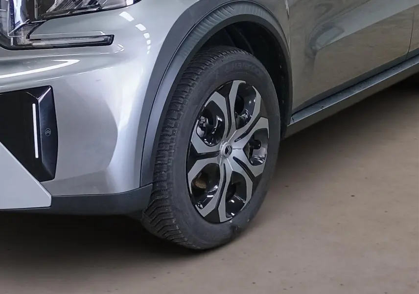 Gros plan sur la roue avant droite et partie du pare-chocs gris Mercury du Citroën C3 Aircross 2025 hybride.
