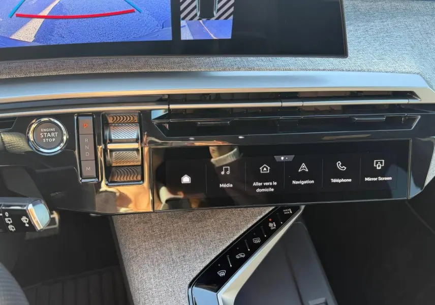 Vue rapprochée du tableau de bord du Peugeot 5008 blanc, montrant l’écran tactile et la commande de boîte automatique.