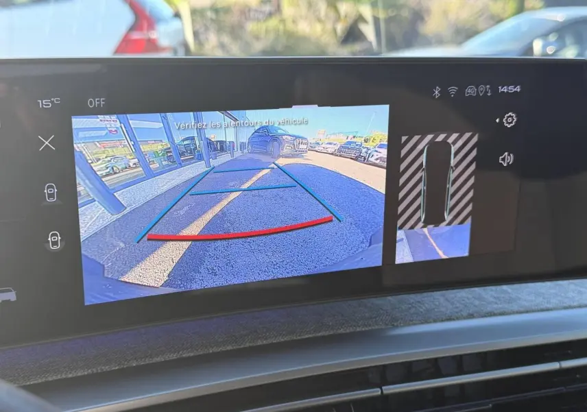 Écran tactile du Peugeot 5008 Hybrid blanc montrant la caméra de recul et l’aide au stationnement en vue arrière.