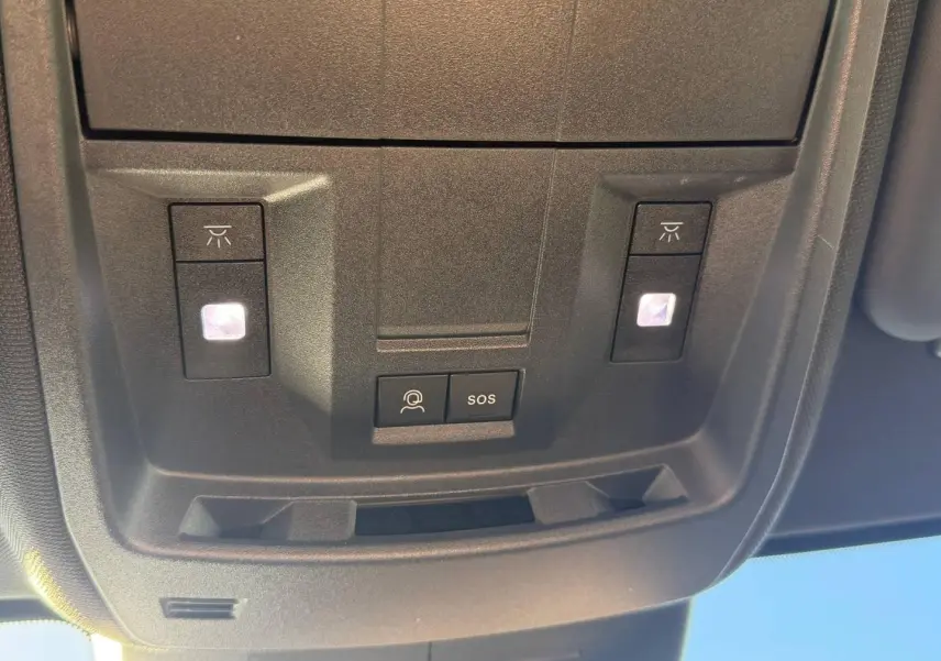 Vue rapprochée du plafonnier intérieur du Peugeot 5008 Hybrid blanc avec boutons d’éclairage et SOS.