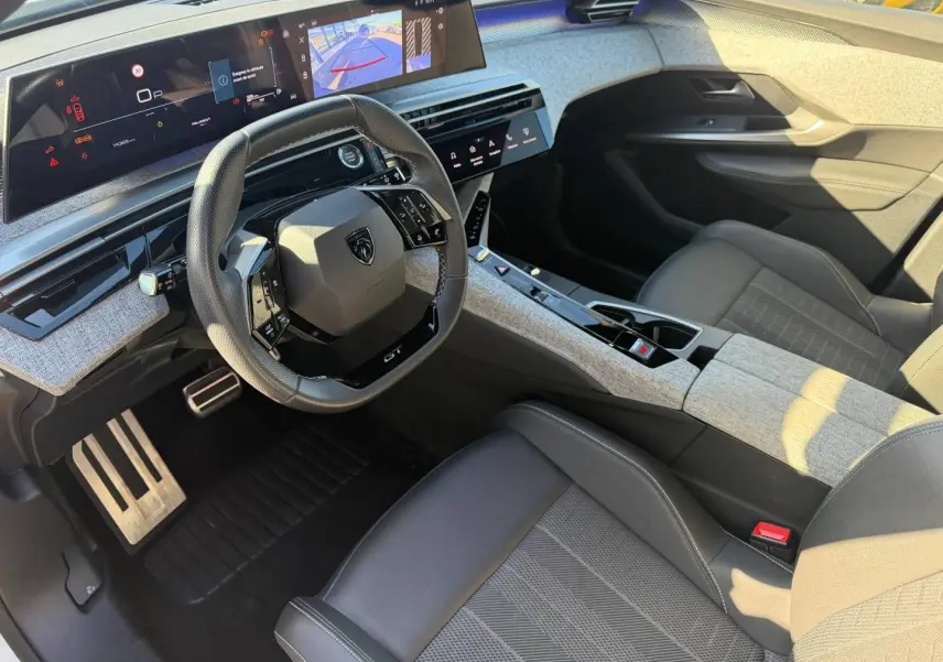 Vue intérieure côté conducteur du Peugeot 5008 Hybrid 145ch GT avec volant cuir multifonction et écran tactile panoramique.