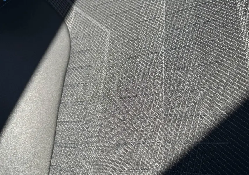 Gros plan sur le tissu gris texturé du siège avant du Peugeot 5008 Hybrid 145ch GT blanc Okénite.