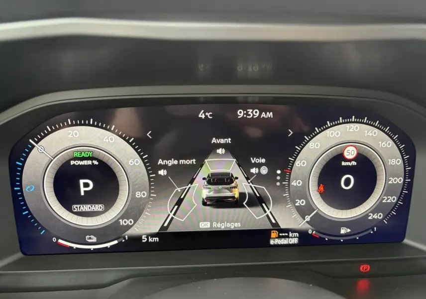 Affichage numérique du tableau de bord du Nissan Qashqai III hybride, montrant la vitesse, la température et l'assistance à la conduite.