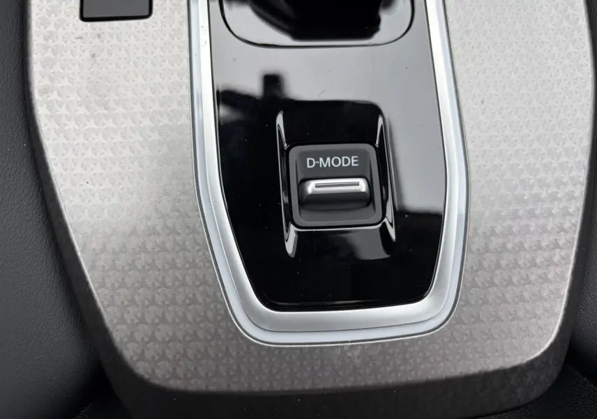 Gros plan sur la console centrale grise avec bouton D-MODE du Nissan Qashqai III 1.5 Hybrid E-Power 2025.