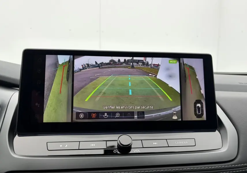 Écran central du Nissan Qashqai 2025 affichant la caméra de recul avec vues latérales et lignes de guidage colorées.