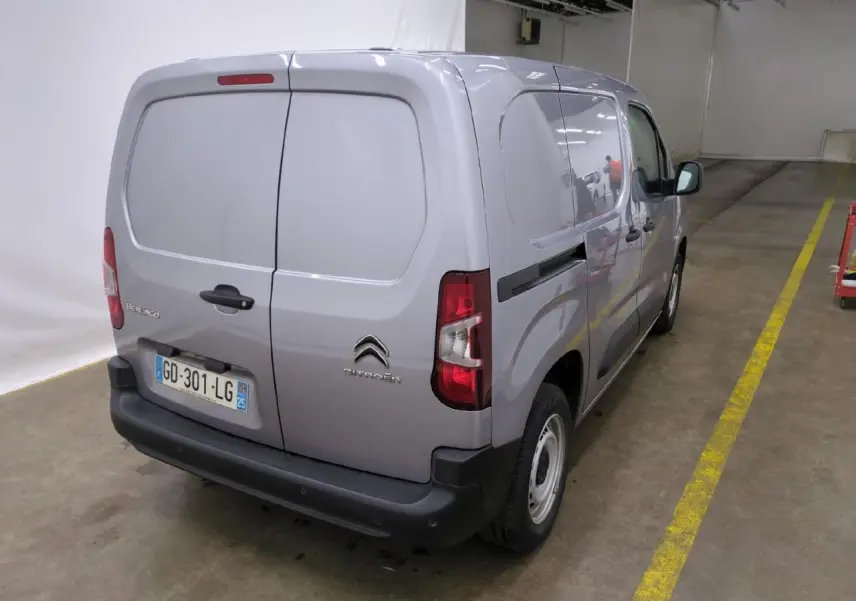 Vue 3/4 arrière droite d’un Citroën Berlingo gris clair utilitaire avec portes battantes arrière et pare-chocs noirs.