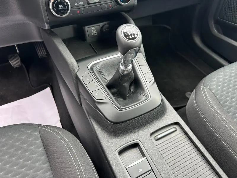 Vue rapprochée de la console centrale du Ford Kuga 2024 avec levier de vitesse manuel et sièges tissu noir.