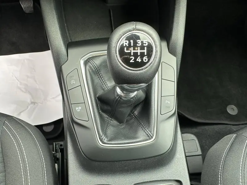 Vue rapprochée du levier de vitesses manuel noir avec six rapports du Ford Kuga 1.5 EcoBoost gris Solar Métallisée, intérieur tissu noir.